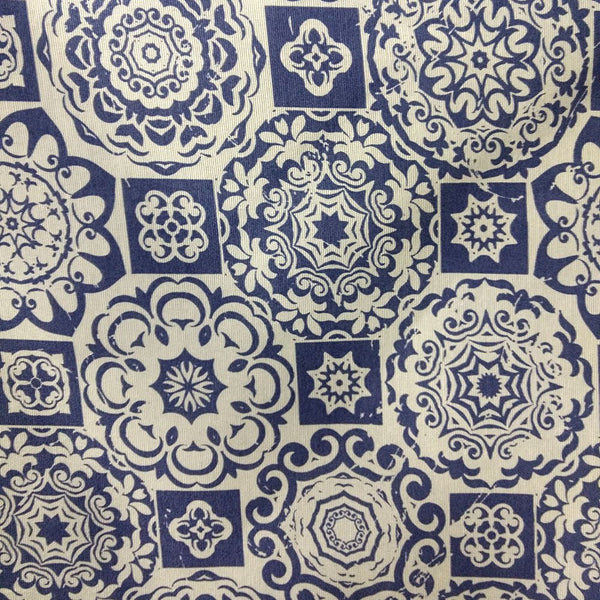 Tela de algodón y poliéster, azul y blanca, con estampado geométrico floral tipo azulejo.